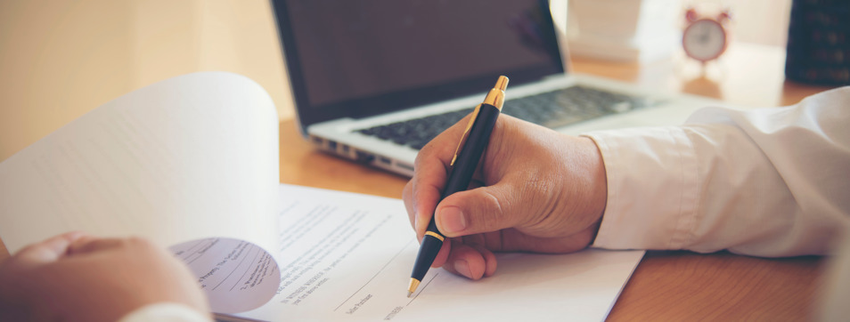 Filling out form next to a laptop