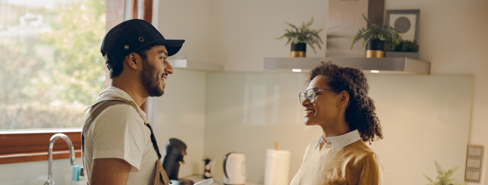 A cheerful man and woman smiling in front of a van