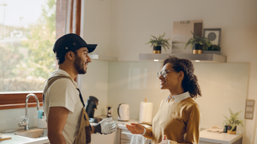 A cheerful man and woman smiling in front of a van