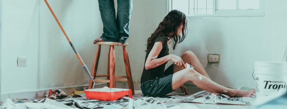 Couple painting a room in a house