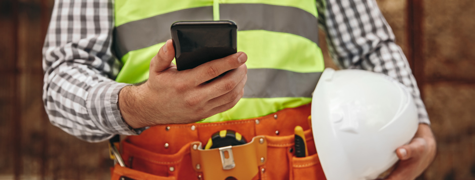 Builder, construction worker using mobile phone