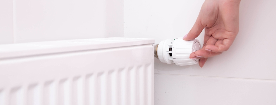 A person turning a radiator on